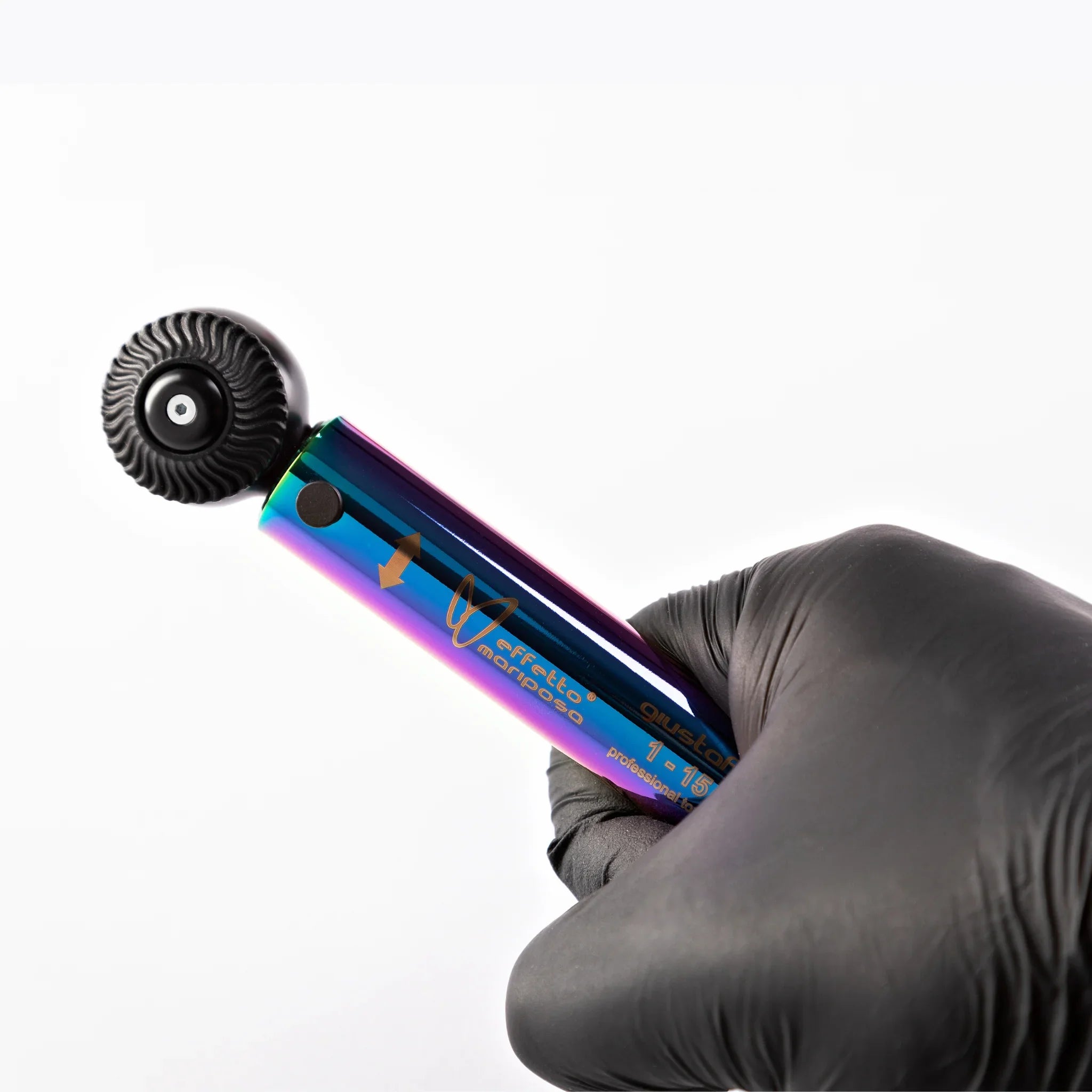 Hand holding a rainbow-finish Effetto Mariposa torque wrench for bikes on white background