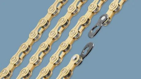 Gold bicycle chains with quick links on blue background, bike component detail
