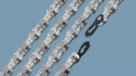 Close-up of silver bicycle chains with quick links on a blue background