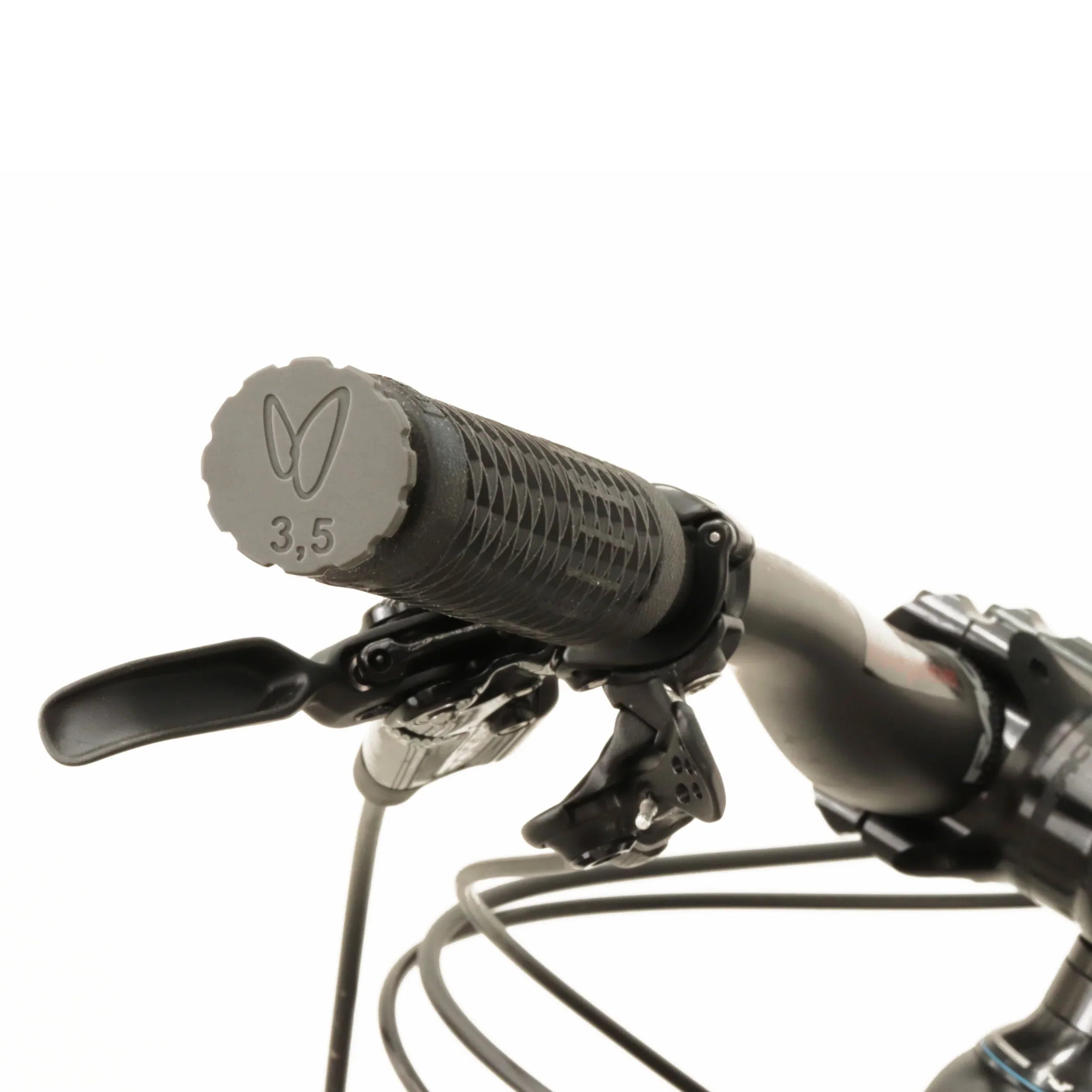 Close-up of a black bicycle handlebar grip with textured surface and tubeless tire plug tool as end cap